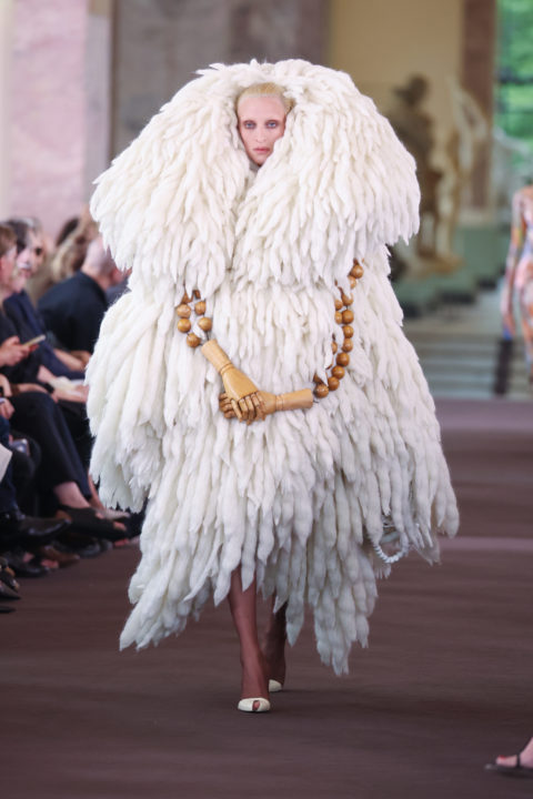 A model in a white fuzzy coat at the Schiaparelli Fall 2023 couture show